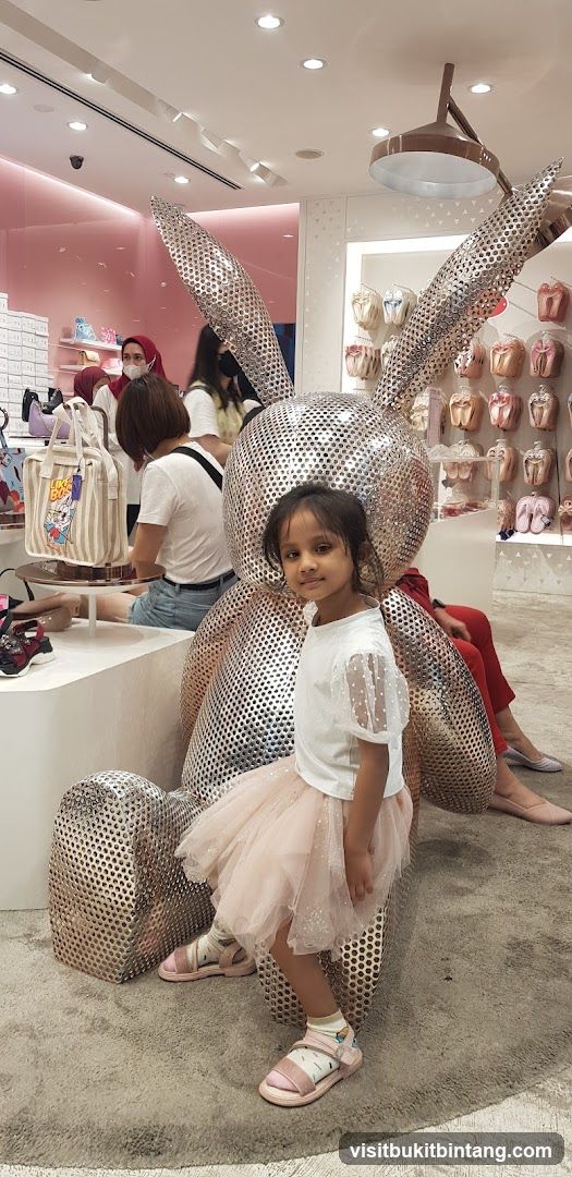 Girl Poses Next to a Large Bunny Sculpture