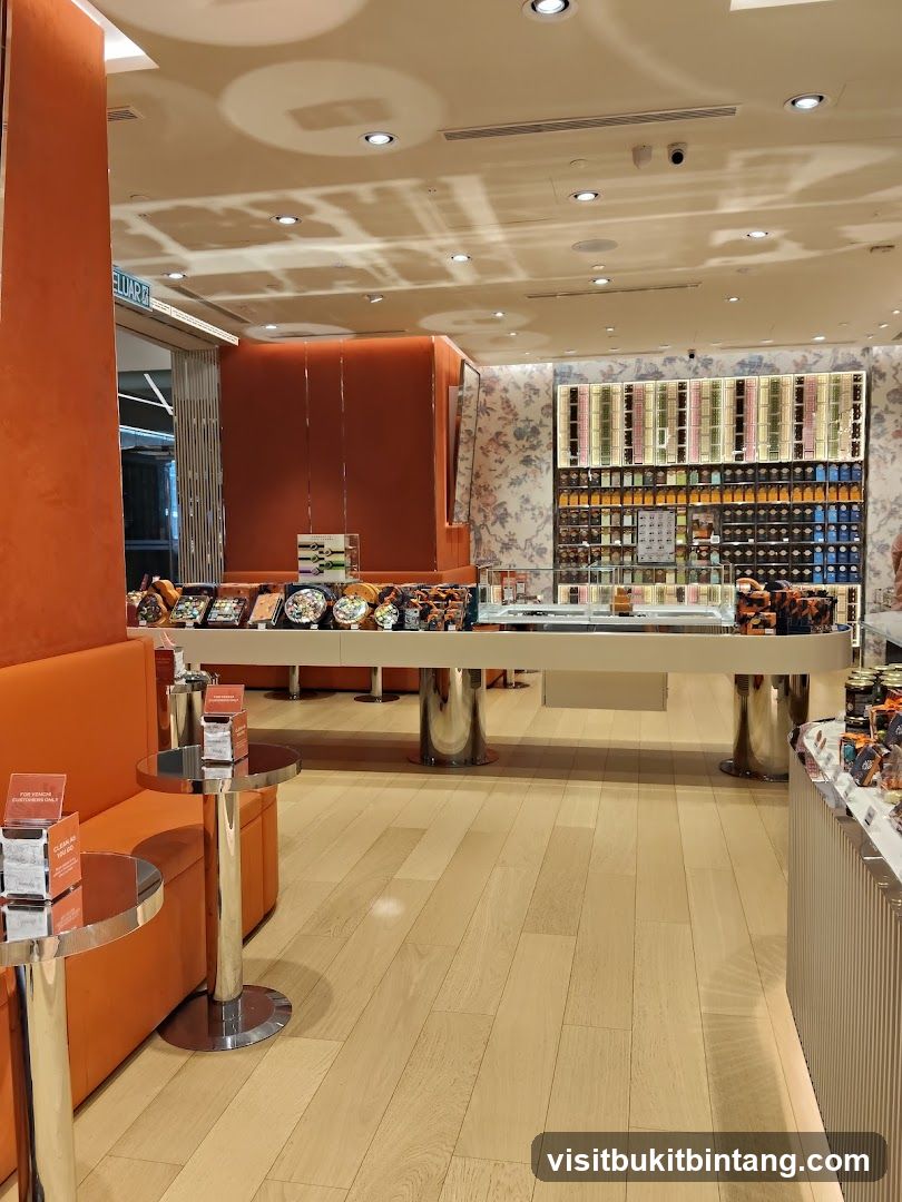 Interior of a well-lit store with orange seating and display cases.