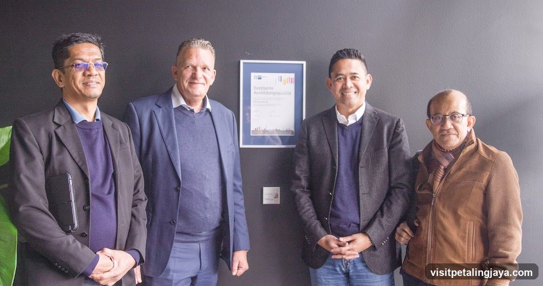 Four men standing in front of a framed certificate
