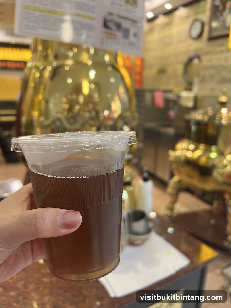 Hand holding a cup of iced tea in a shop