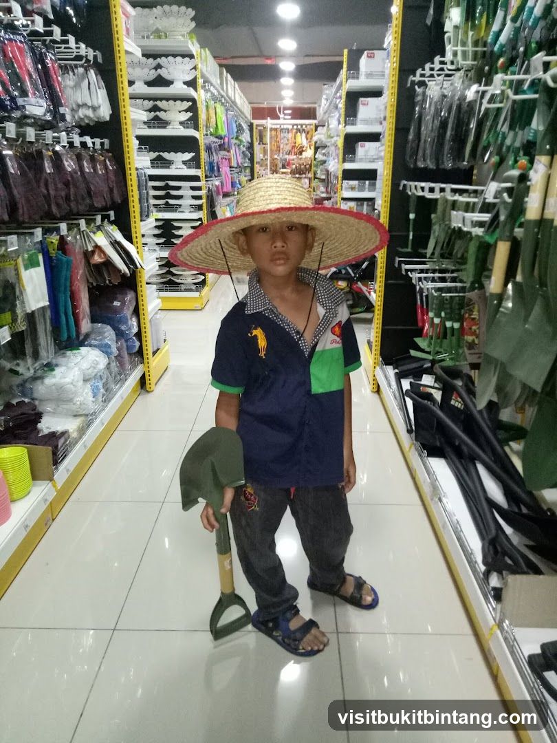 Boy in a straw hat holding a shovel