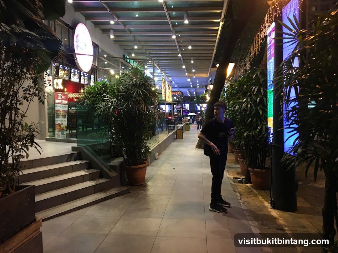 Nighttime street scene with a man and a restaurant storefront