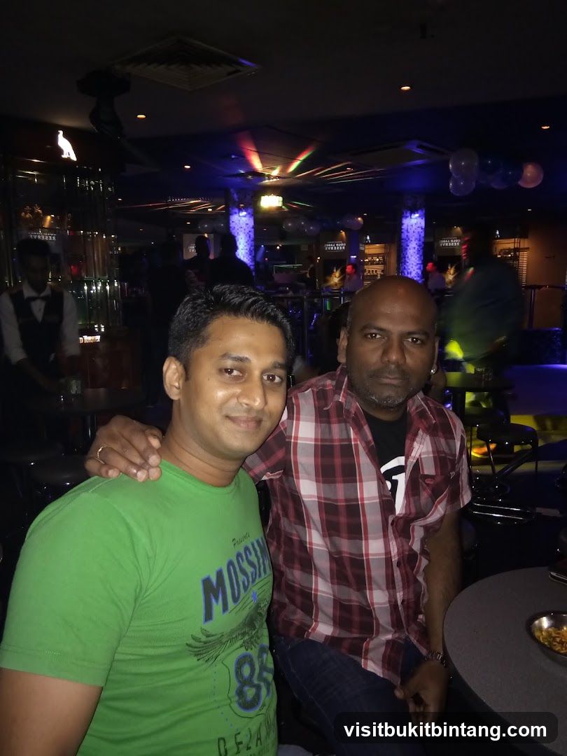 Two men posing in a dimly lit bar