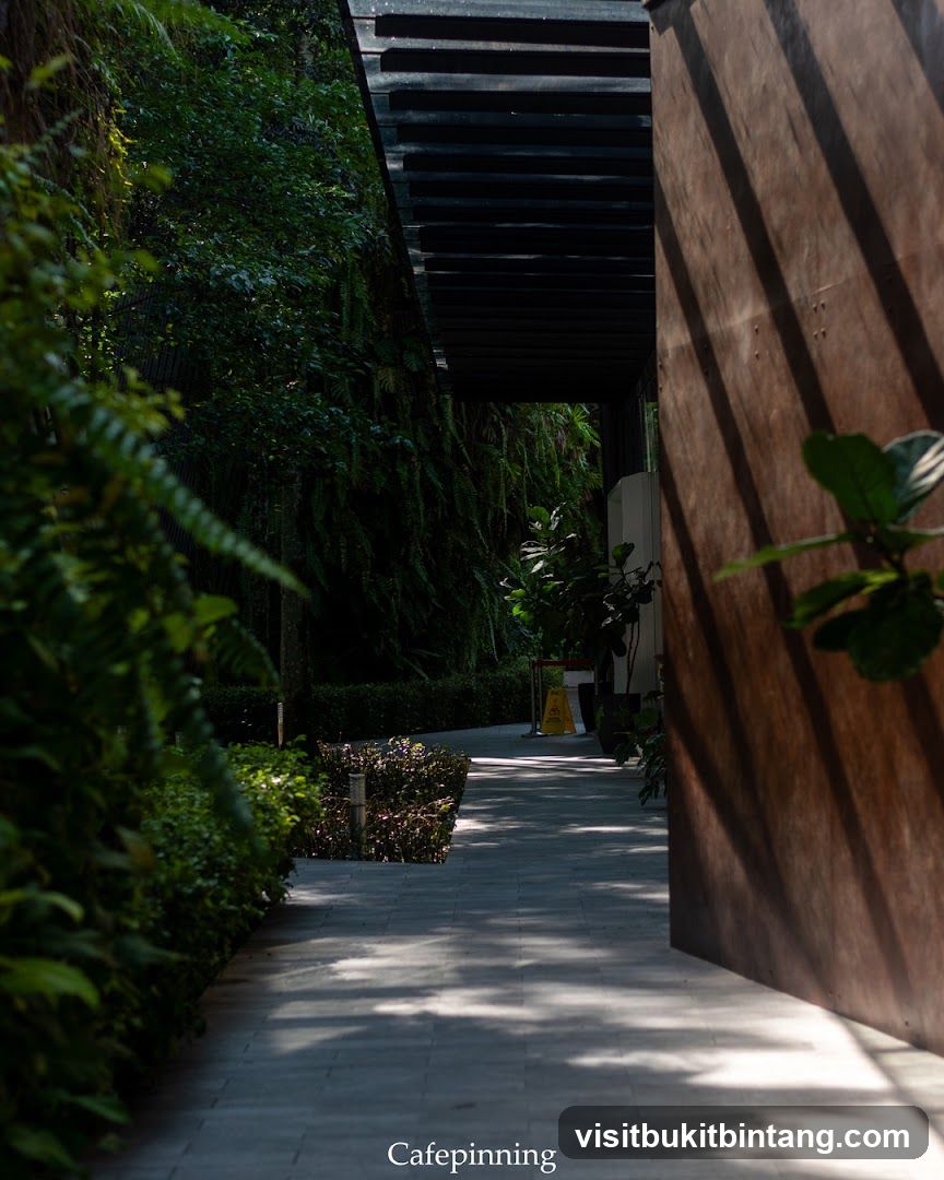 Pathway to a building entrance with lush greenery