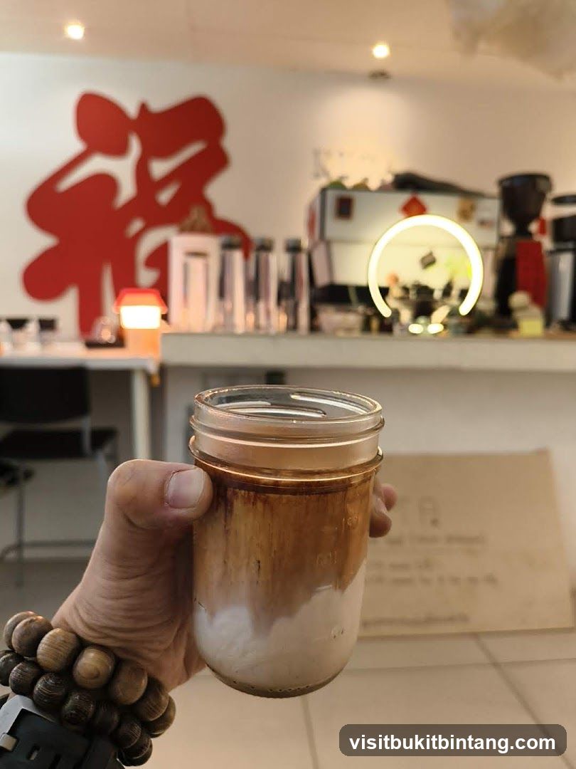 Hand holding a layered coffee drink