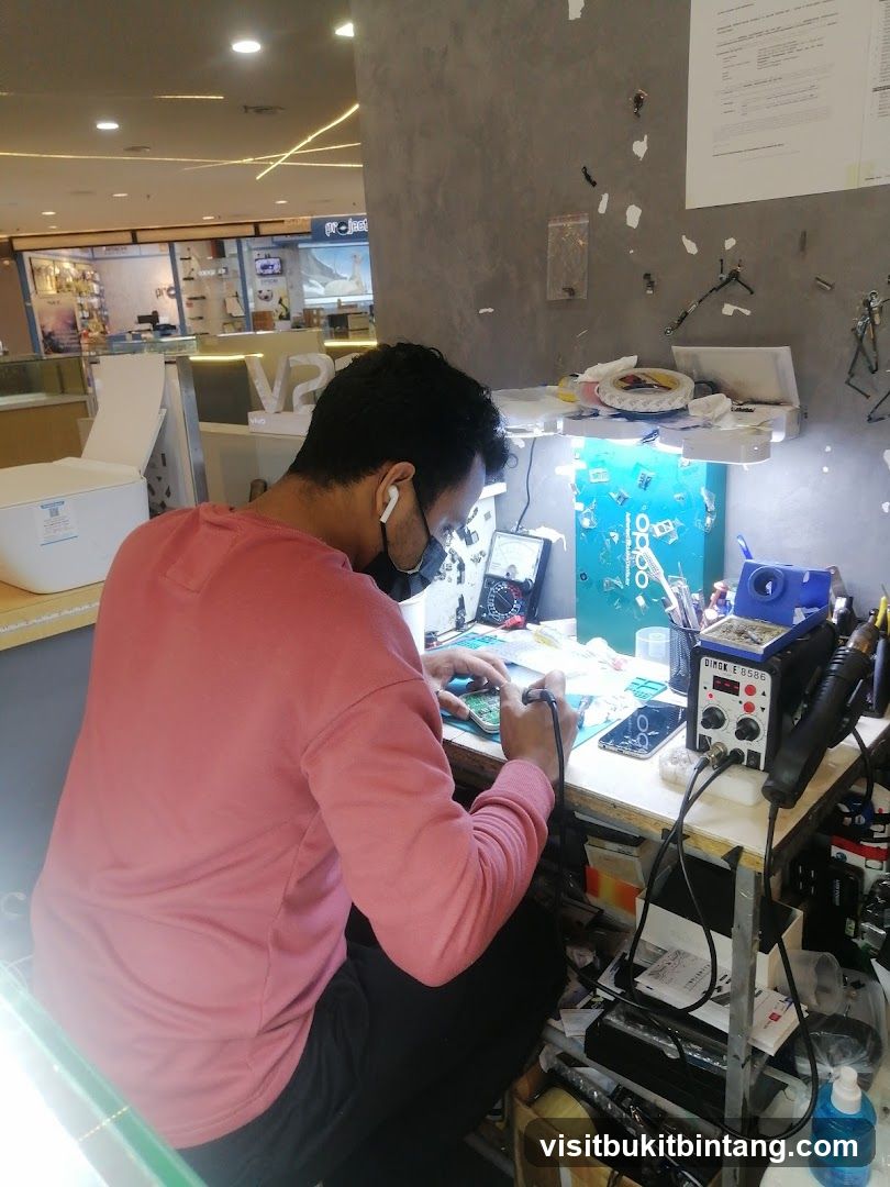 Electronics repair technician working at a desk