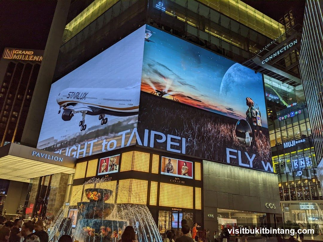 Nighttime Cityscape with Digital Billboards and Fountain