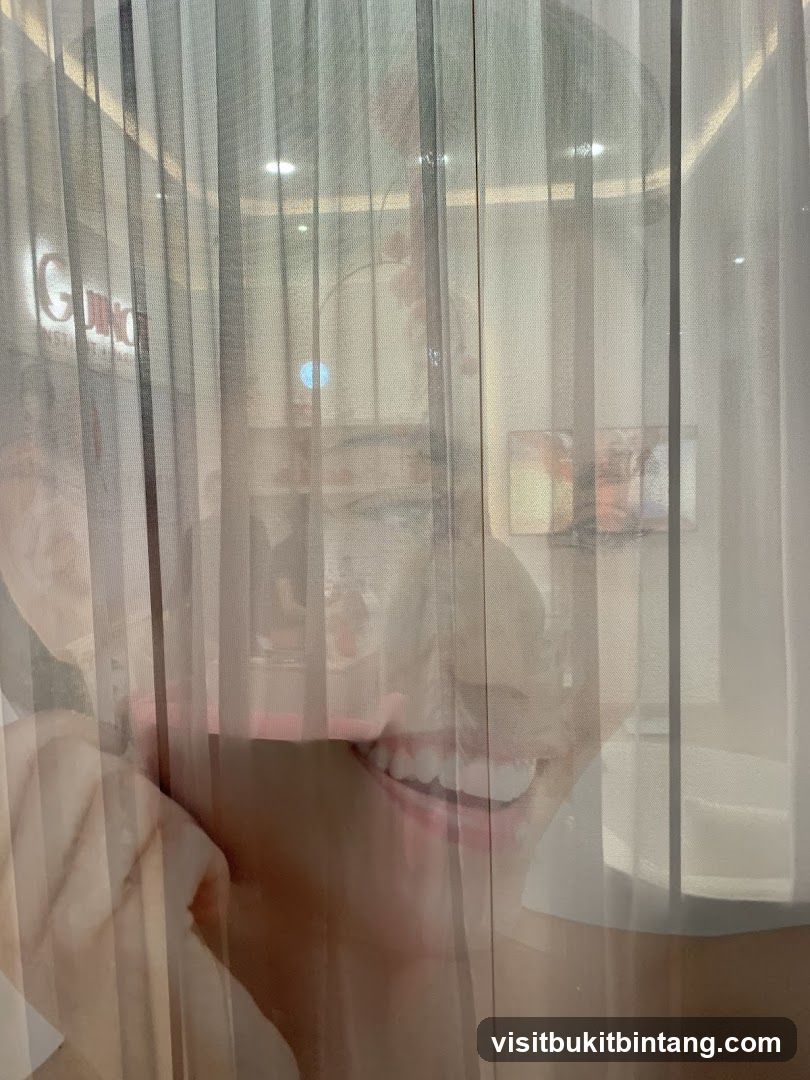 Reflection of a smiling person behind sheer curtains
