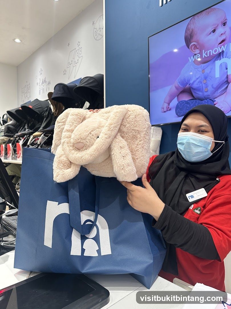 Employee holding a plush toy and shopping bag