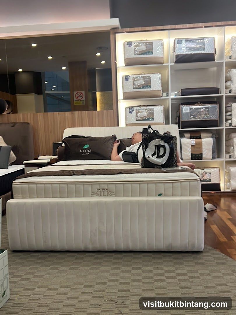 Man resting on a bed in a mattress store