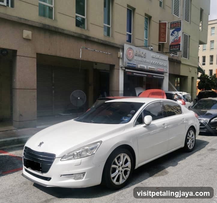 White Peugeot parked in front of building