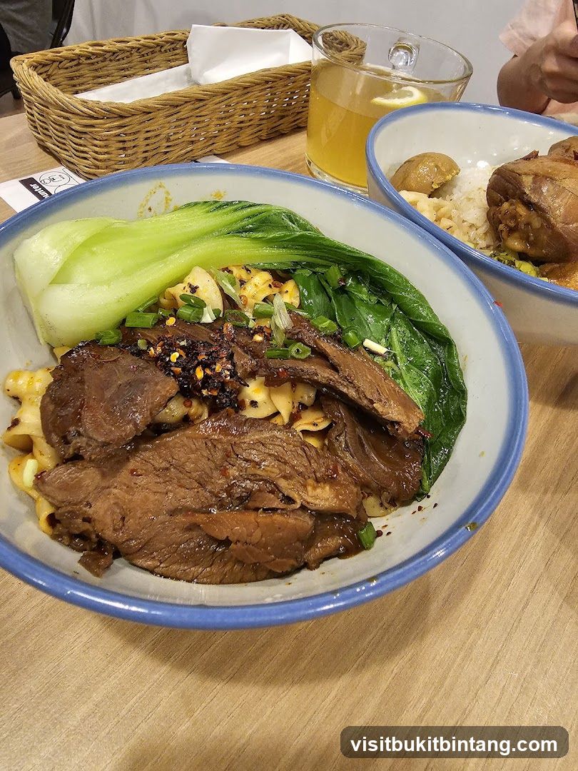 Beef noodle soup with bok choy and a side of braised meat and rice