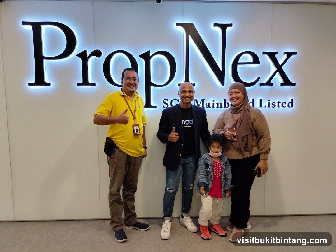 People Posing in Front of PropNex Signage