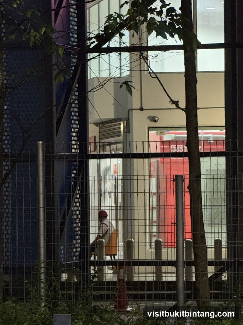 Person sitting in a chair near a red door