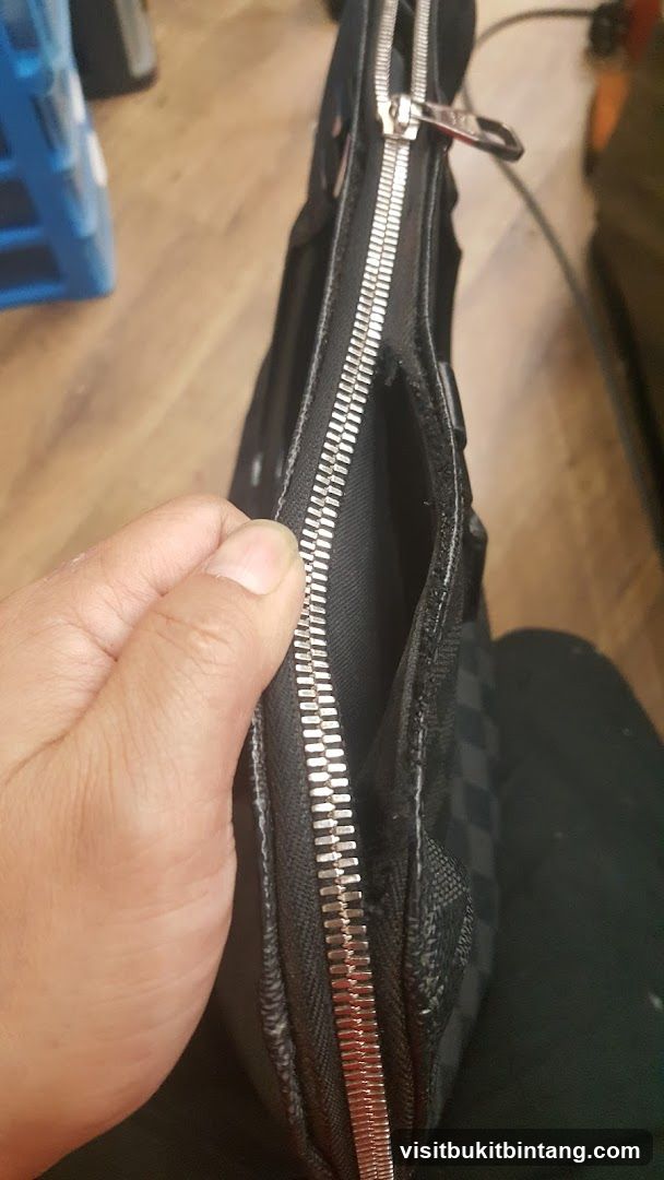 Close-up of a black checkered bag with a zipper
