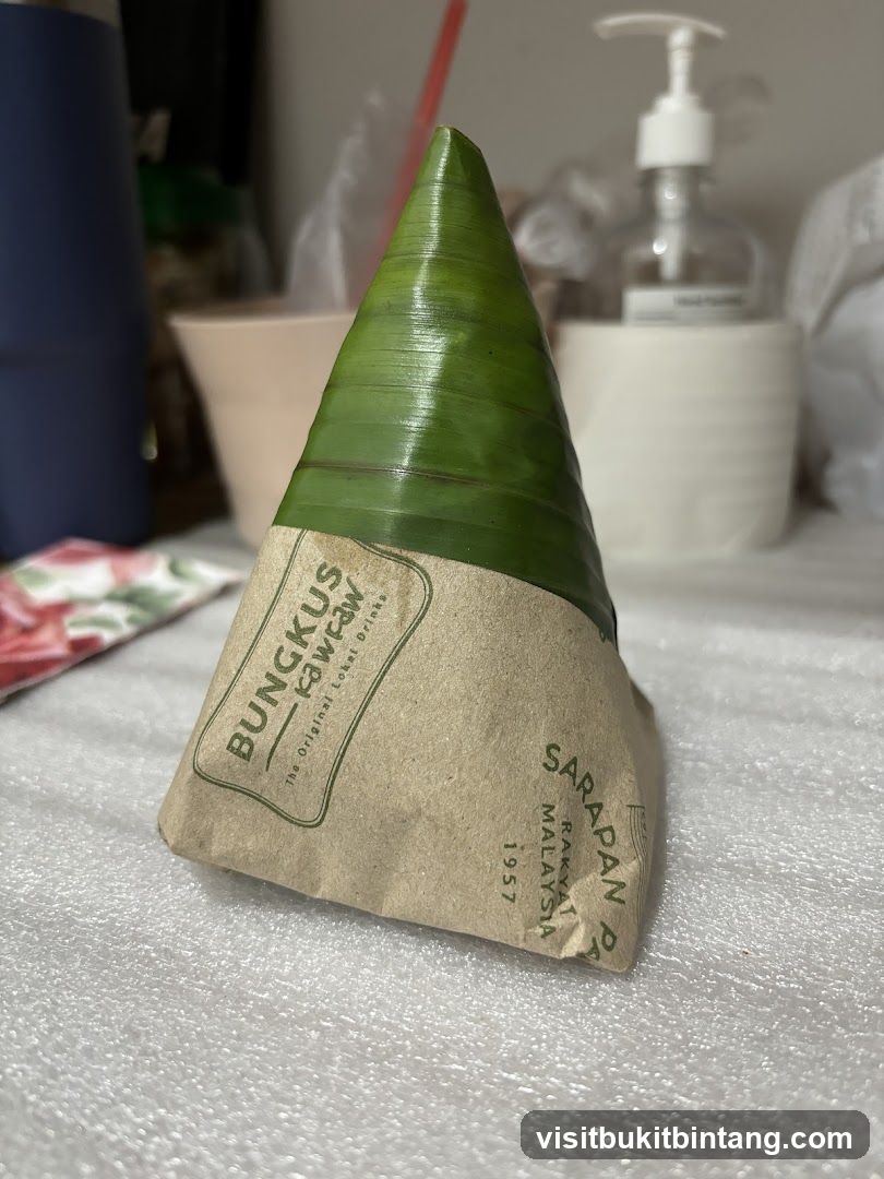 Food item wrapped in banana leaf and paper