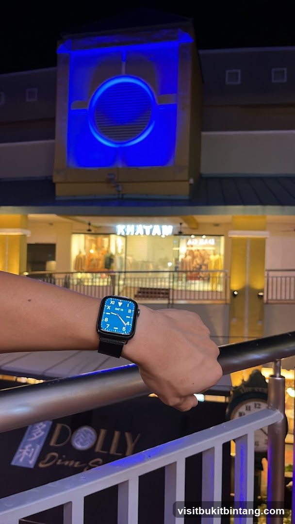 Person wearing a smartwatch in front of shops