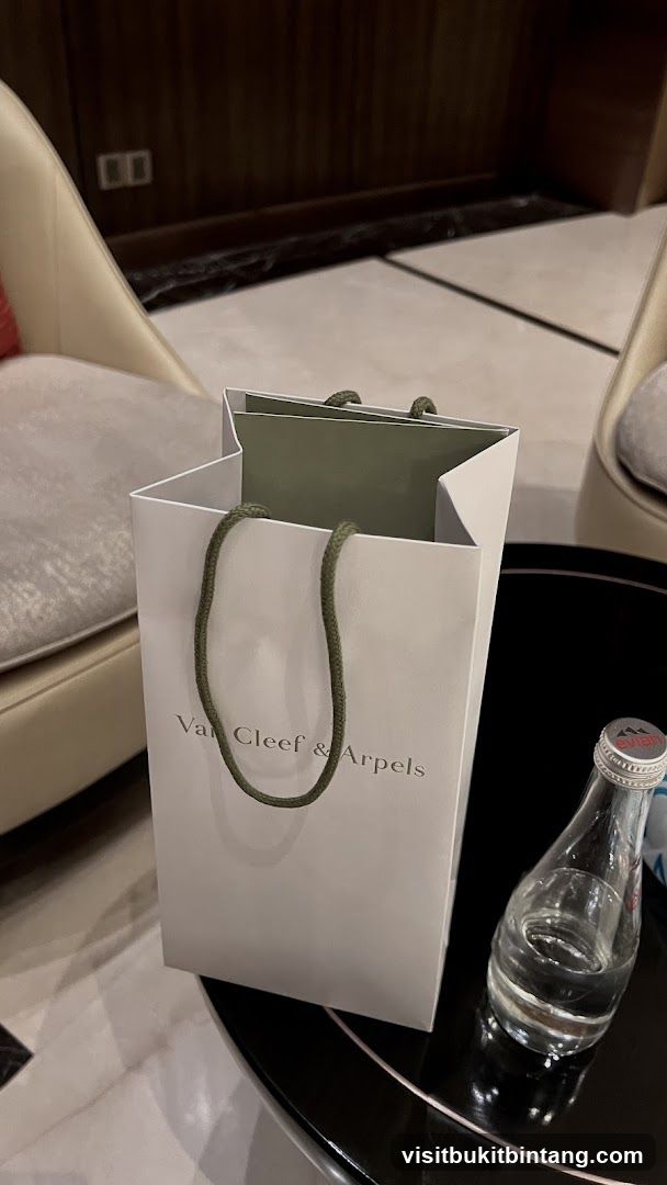 Van Cleef & Arpels shopping bag and Evian water bottle
