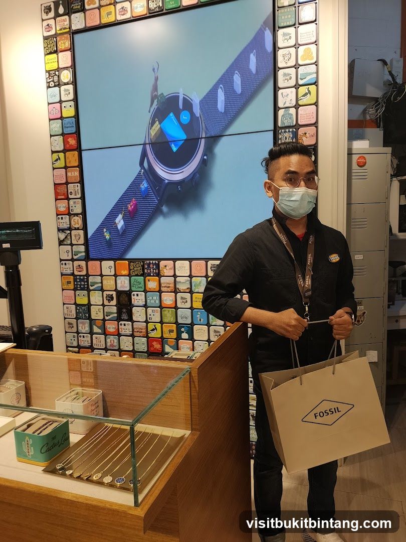 Man holding a Fossil shopping bag in a store