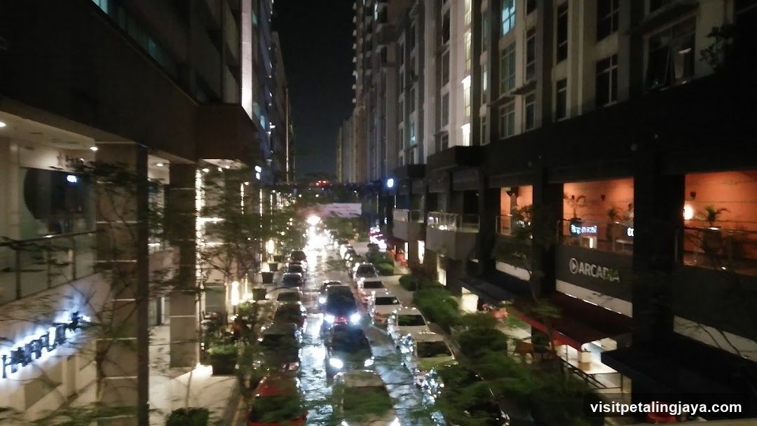 Night street scene with parked cars and illuminated buildings