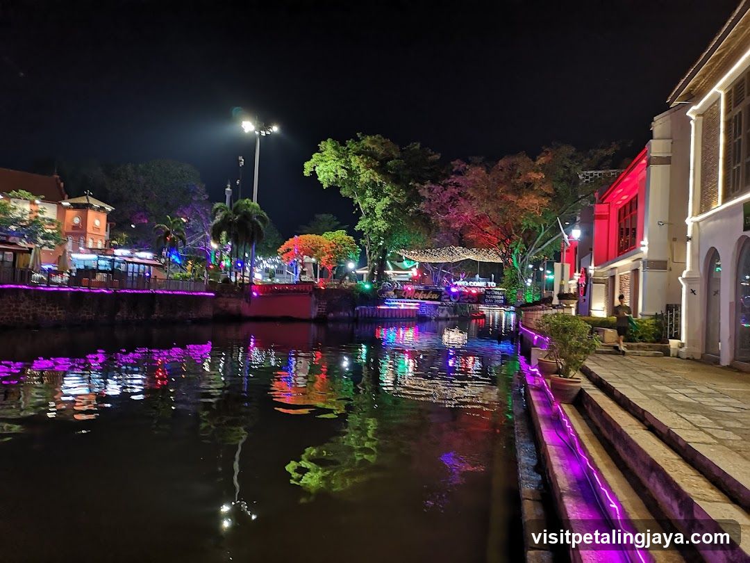 Night canal scene with illuminated buildings and reflections