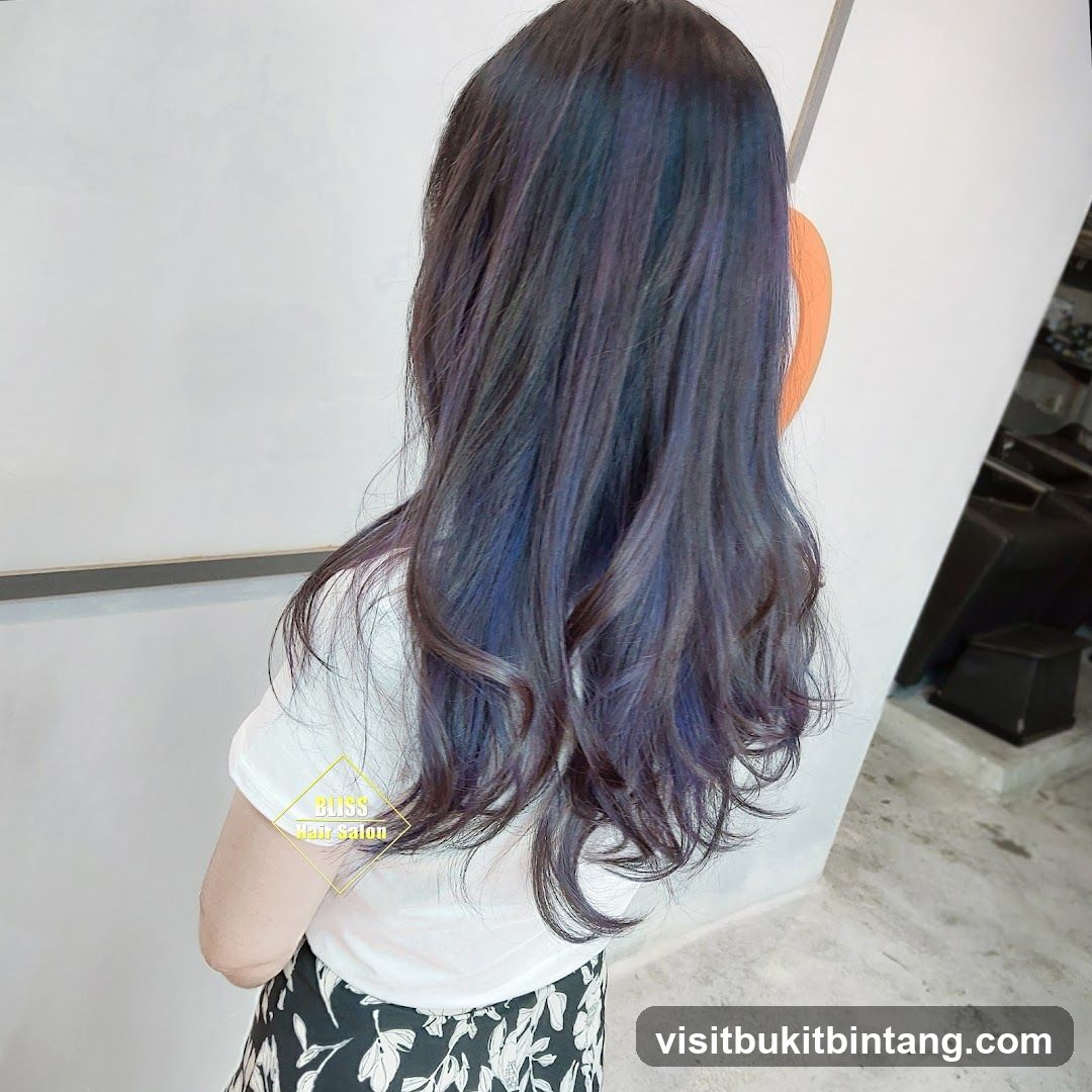 Woman with long, wavy, dark hair with blue and purple highlights