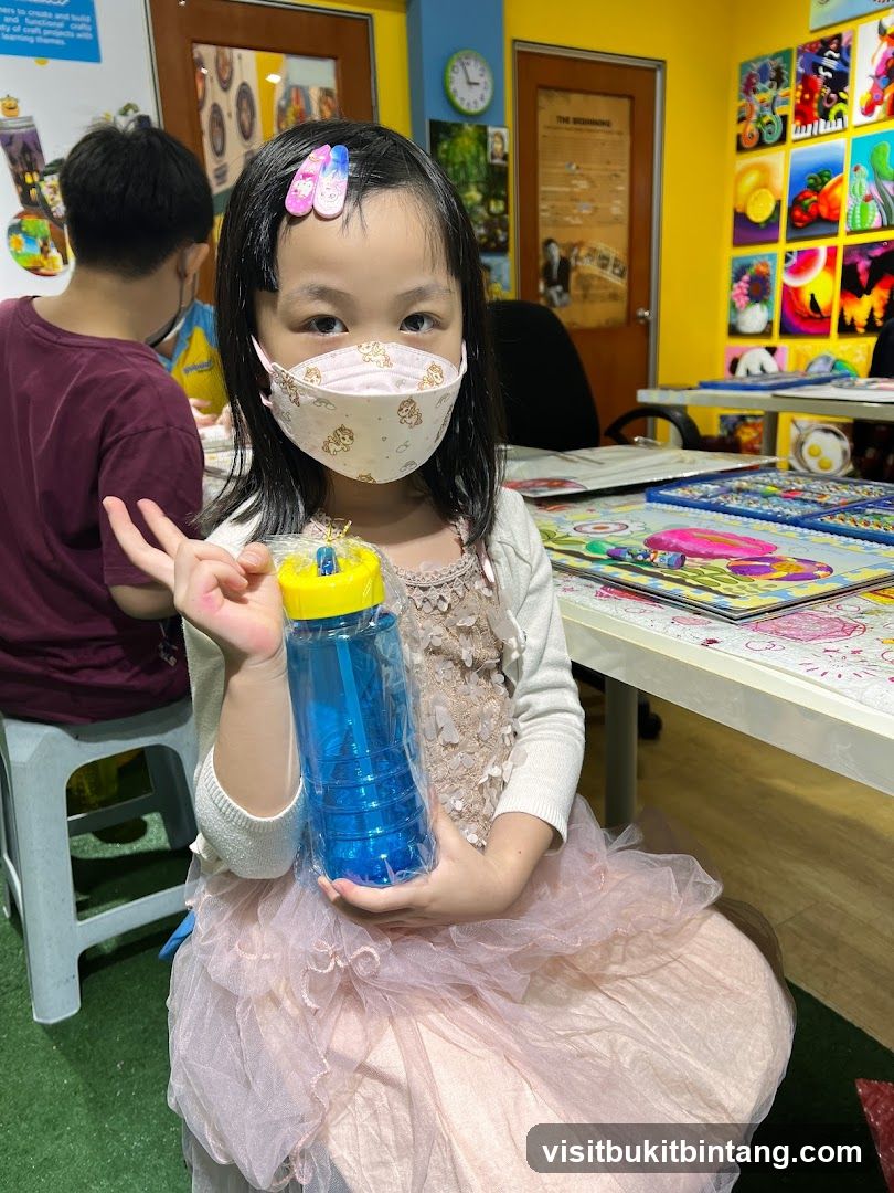 Child holding a blue bottle