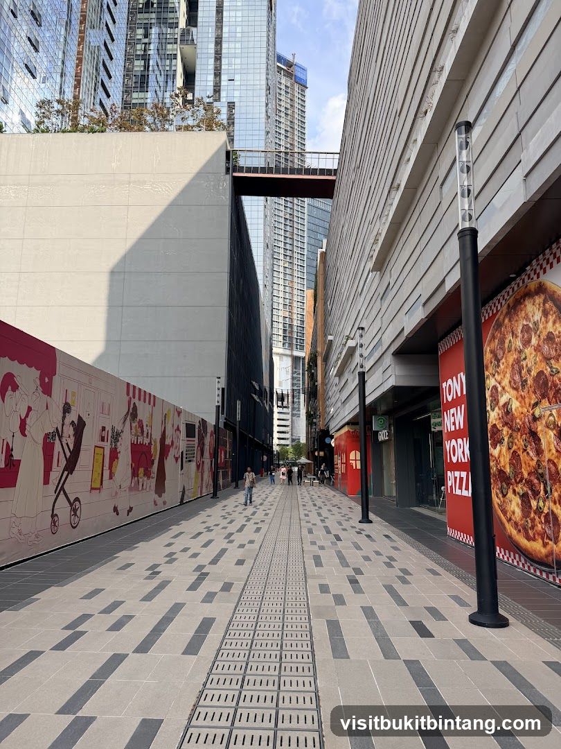Outdoor walkway with modern buildings and pizza advertisement