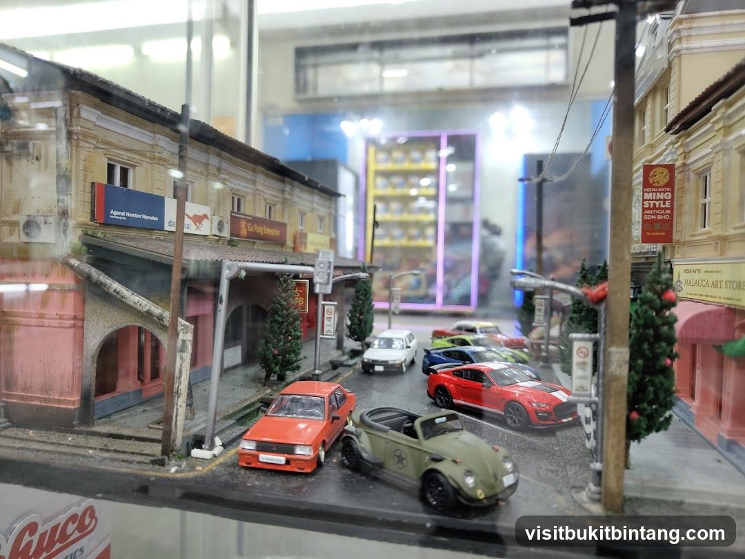 Diorama of a street scene with miniature cars and buildings