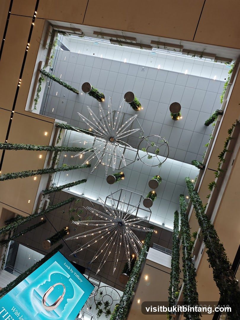 Interior of a modern shopping mall with decorative lighting and greenery.