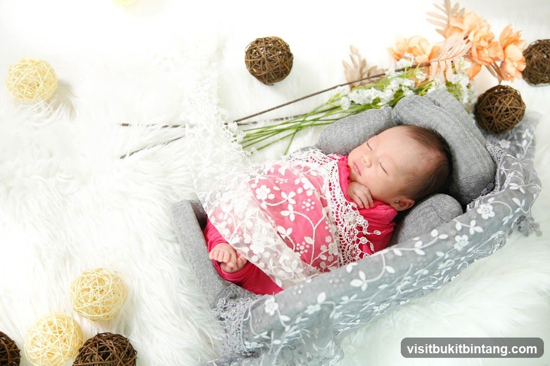 Newborn baby sleeping in a basket with floral decorations