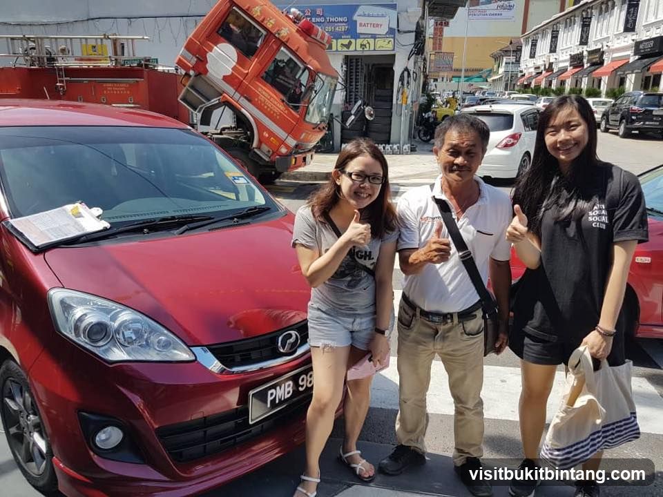 People posing with a fire truck and car