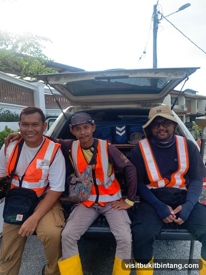 Three men in safety vests sitting in the back of a vehicle
