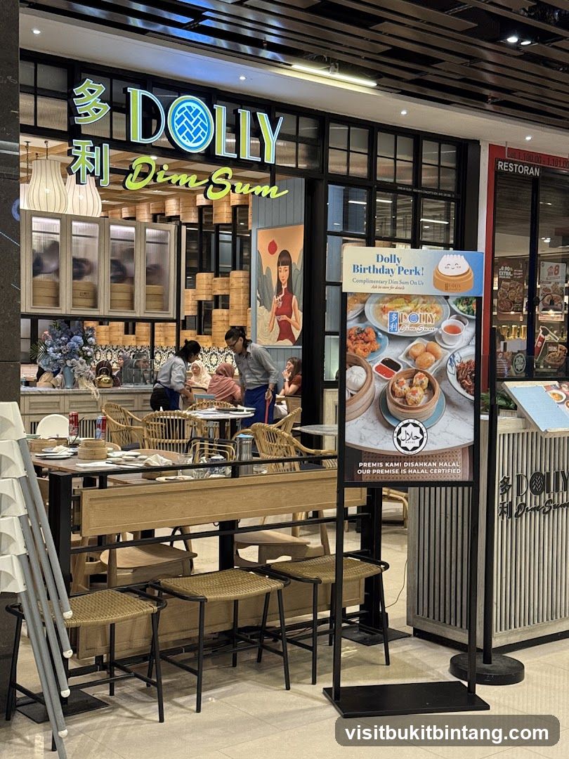 The exterior of a Dolly Dim Sum restaurant with its prominent signage. The storefront features large windows and an inviting interior with tables and chairs. A promotional sign for a "Dolly Birthday Perk" is displayed outside, showcasing various dim sum dishes and stating that the premise is Halal certified.