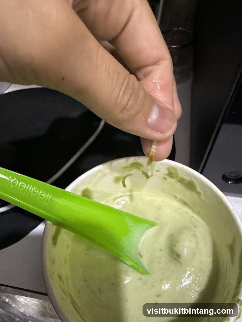 Hand holding food over a bowl