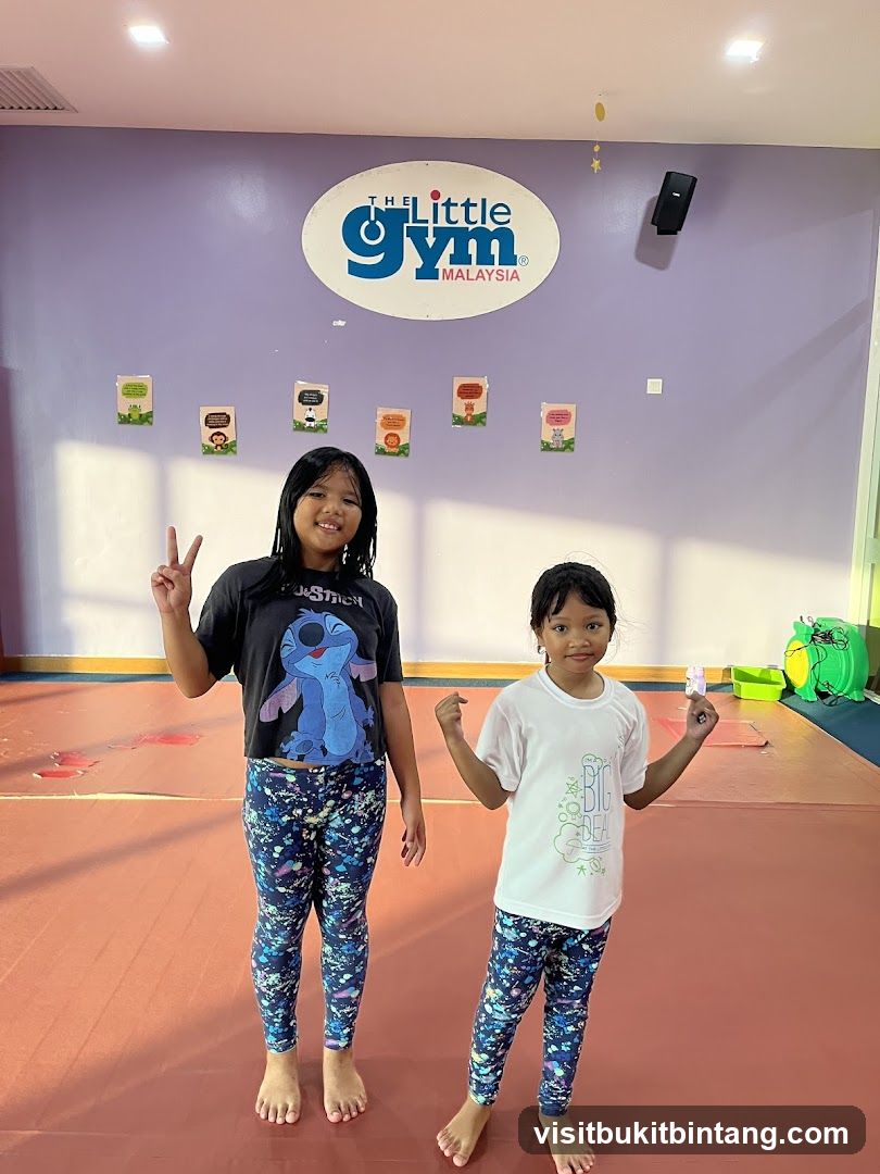 Two girls posing in front of a logo