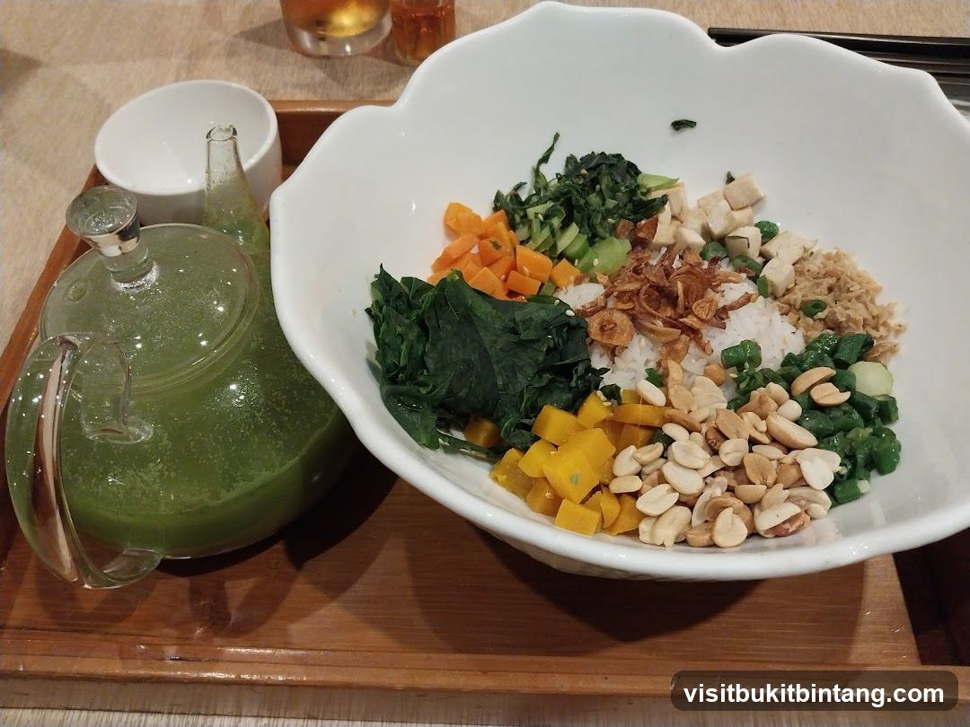 Rice bowl with assorted toppings and a teapot of green liquid
