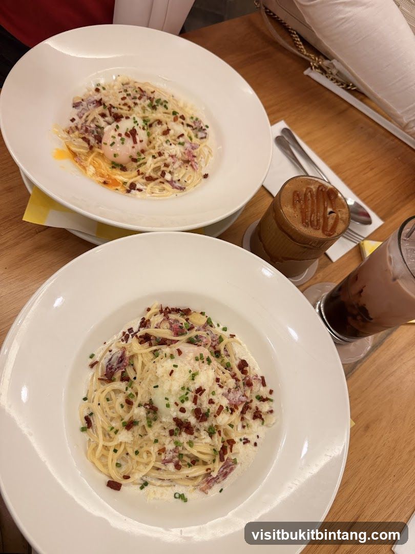 Two plates of pasta with drinks