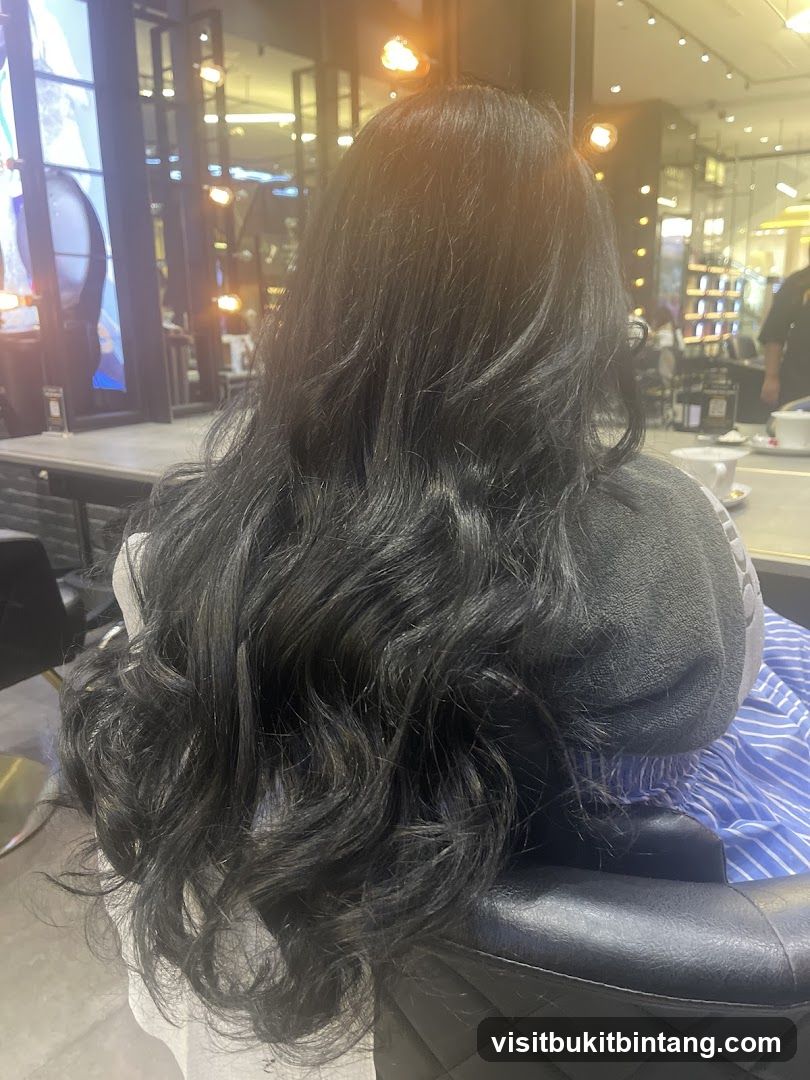 Woman with long, wavy black hair in a salon