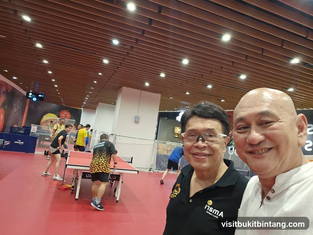 Two men smiling at a table tennis facility
