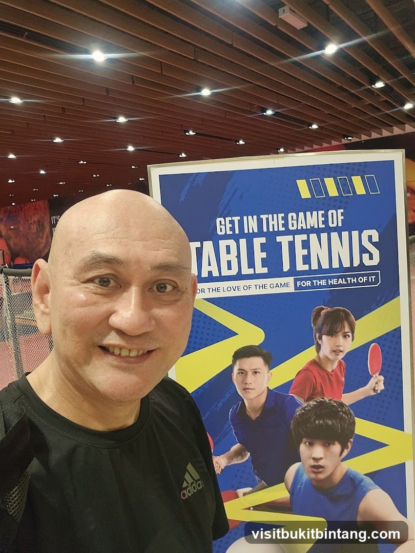 Man posing with table tennis advertisement