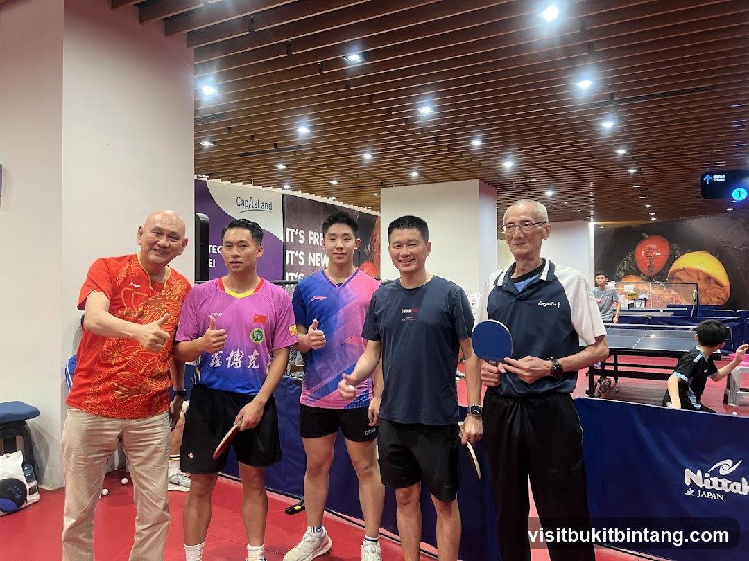 Group of men posing for a photo at a table tennis facility