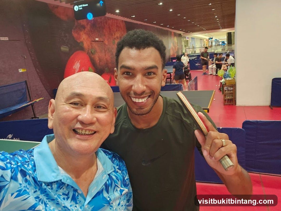 Two men smiling at a table tennis venue
