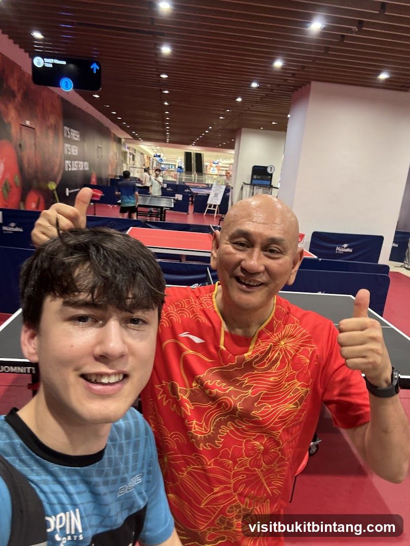 Two men giving thumbs up in a table tennis arena