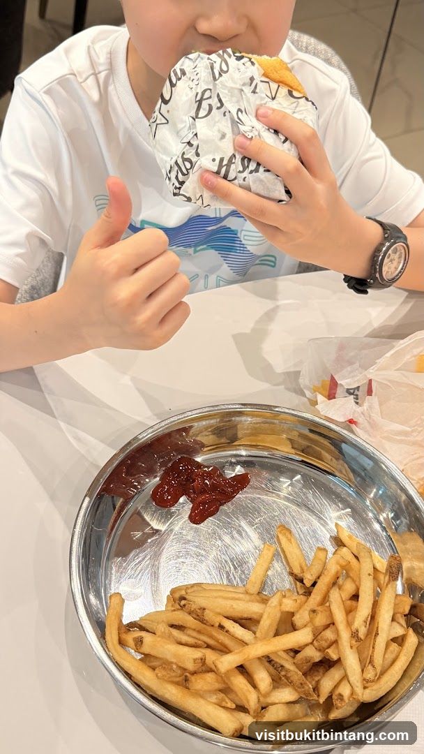 Boy eating a burger and fries