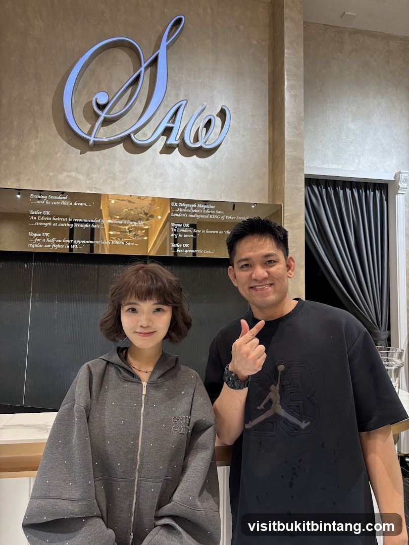 Two people posing in front of a salon sign