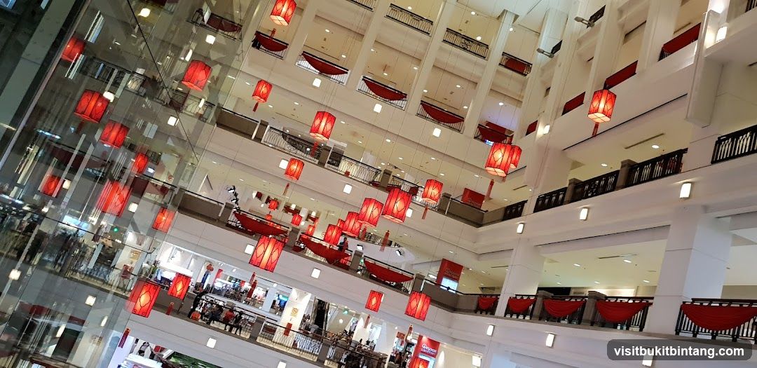 Interior of a multi-level shopping mall decorated with red lanterns.