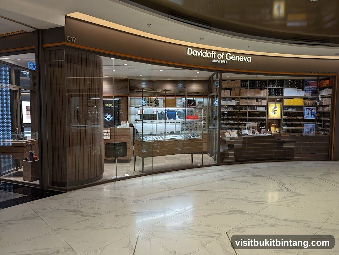 The exterior of a Davidoff of Geneva store, featuring a large glass storefront displaying various products. The store's name and logo are prominently displayed above the entrance. Inside, shelves are stocked with boxes of cigars and other merchandise.