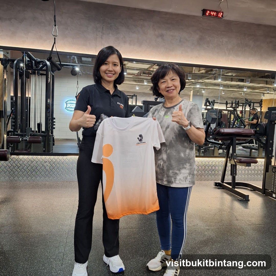 Two women holding a t-shirt in a gym