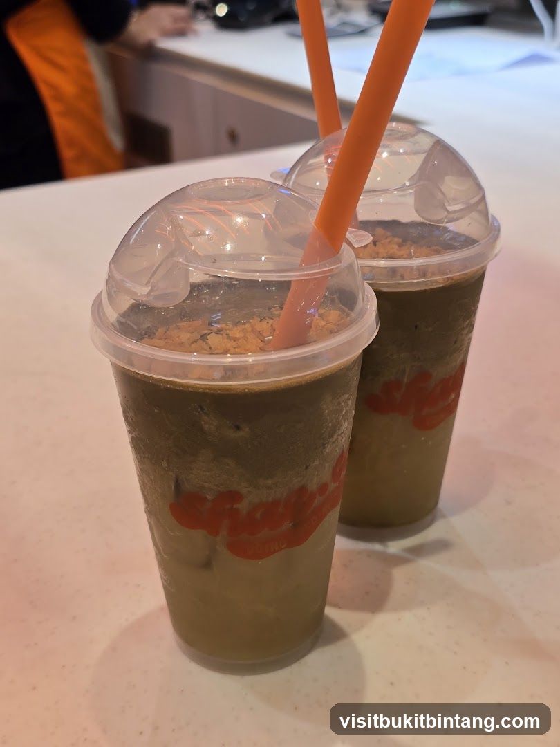 Two iced drinks with orange straws
